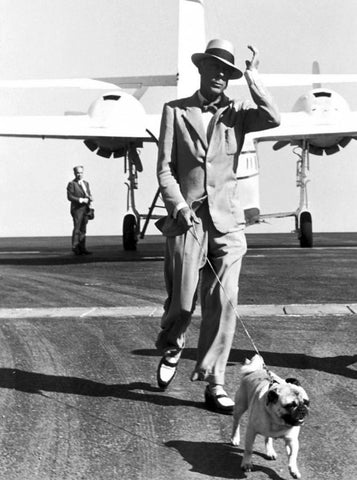 king Edward VIII walking his pug away from a plane dressed in two-tone shoes.