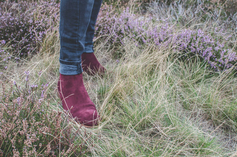 Hamilton suede Chelsea boot in bordo modelled in a field of heather with blue jeans