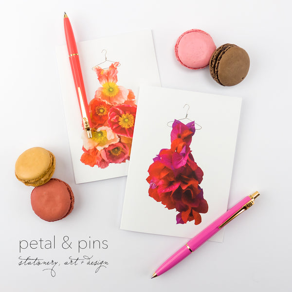 two greeting cards featuring images of dresses made from flowers by petal & pins styled with macarons and pens in orange and pink colours