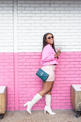 black-haired-woman-wearing-a-Y2K-style-mini-skirt-against-a-pink-wall