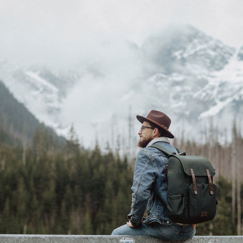 Adventurous man wearing a brown hat and backpack