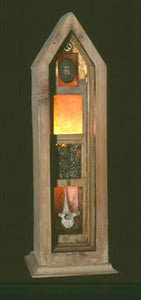 Un-namable. wood, stone, thistle seeds, fern leaves, bone, light. 24″x7″x7,” 2002