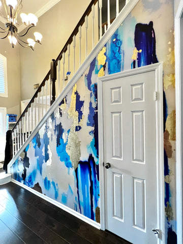 Luxury home entryway/staircase with blue, gold and white abstract wallpaper mural installed with real gold leaf application.