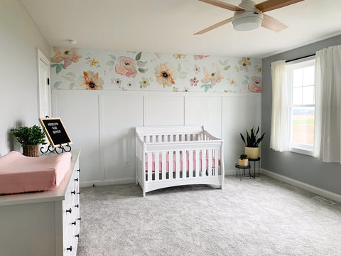 Calming white nursery theme with floral wallpaper mural.