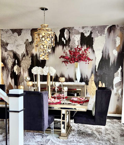 Maximalist dining room decor with black, gold and white abstract wallpaper mural and luxury chandelier.