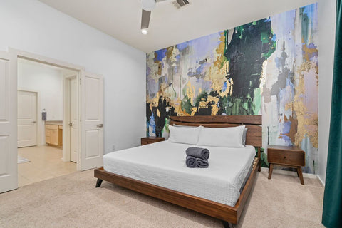 Bedroom interior design with with colorful accent wall decorated with green and gold abstract wallpaper mural with a peel and stick application.