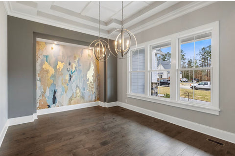 Newly renovated living room with stunning accent wall covered with blue and gold abstract wallpaper by Vivian Ferne.