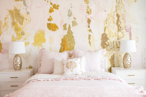 Cozy teen bedroom with pink theme and large pink abstract wallpaper mural with gold leafing.