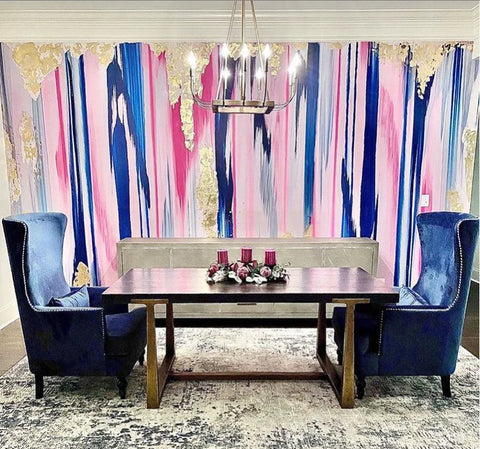 Dining room interior design with large abstract wallpaper design. The design includes pinks, fuchsias, navy and gold.