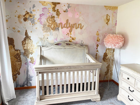 Cozy childrens' nursery with pink abstract wallpaper mural. Gold leafing and shades of pink make this peel and stick wallpaper the best way to add texture, style and unique qualities to your nursery decor.