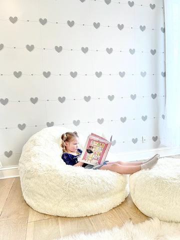 Kids reading room fully designed with monochromatic grey hearts. DIY wallpaper installation - great backdrop for kids reading or activity room.