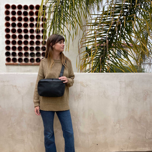 woman carrying sling bag across her chest