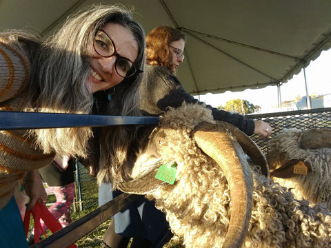 Natalia having her hair eaten by a friendly goat, with Sara in the background