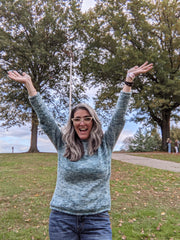 Natalia with her arms up in the air showing of the sweater she finished that same morning at the NY Sheep and Wool festival.