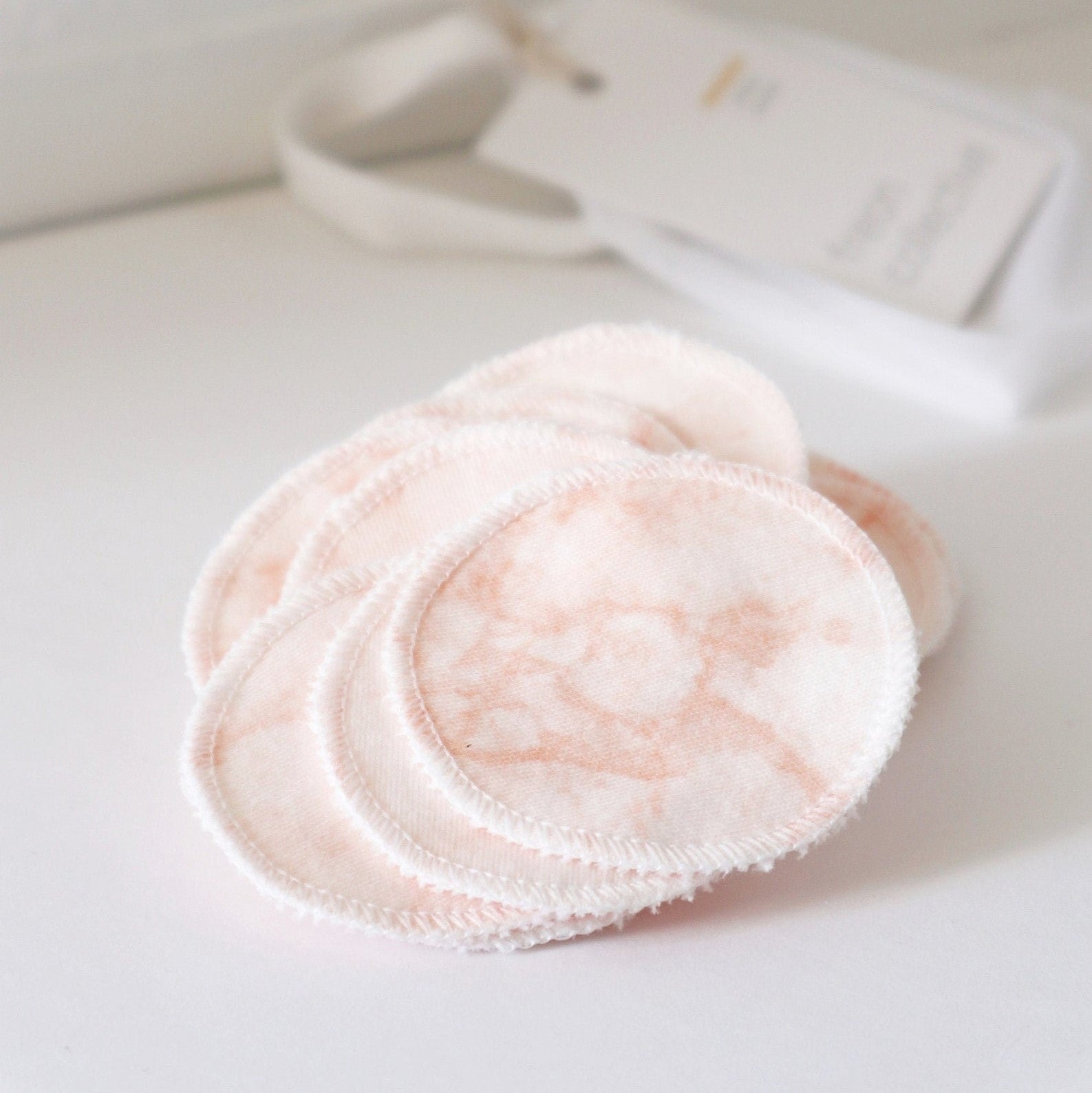 Pink reusable cotton pads on a white counter.