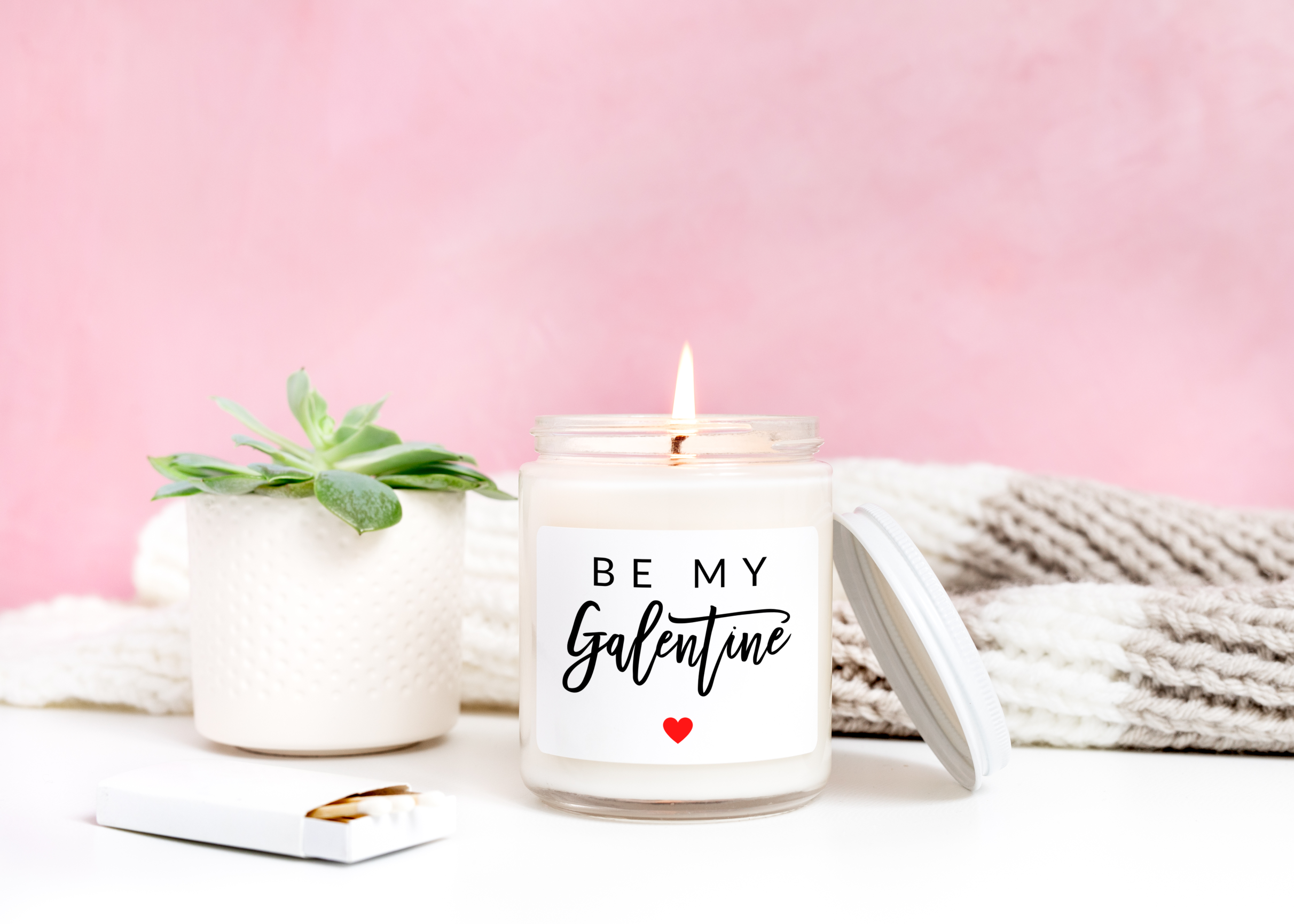 Be my galentine candle lit in front of a pink background.