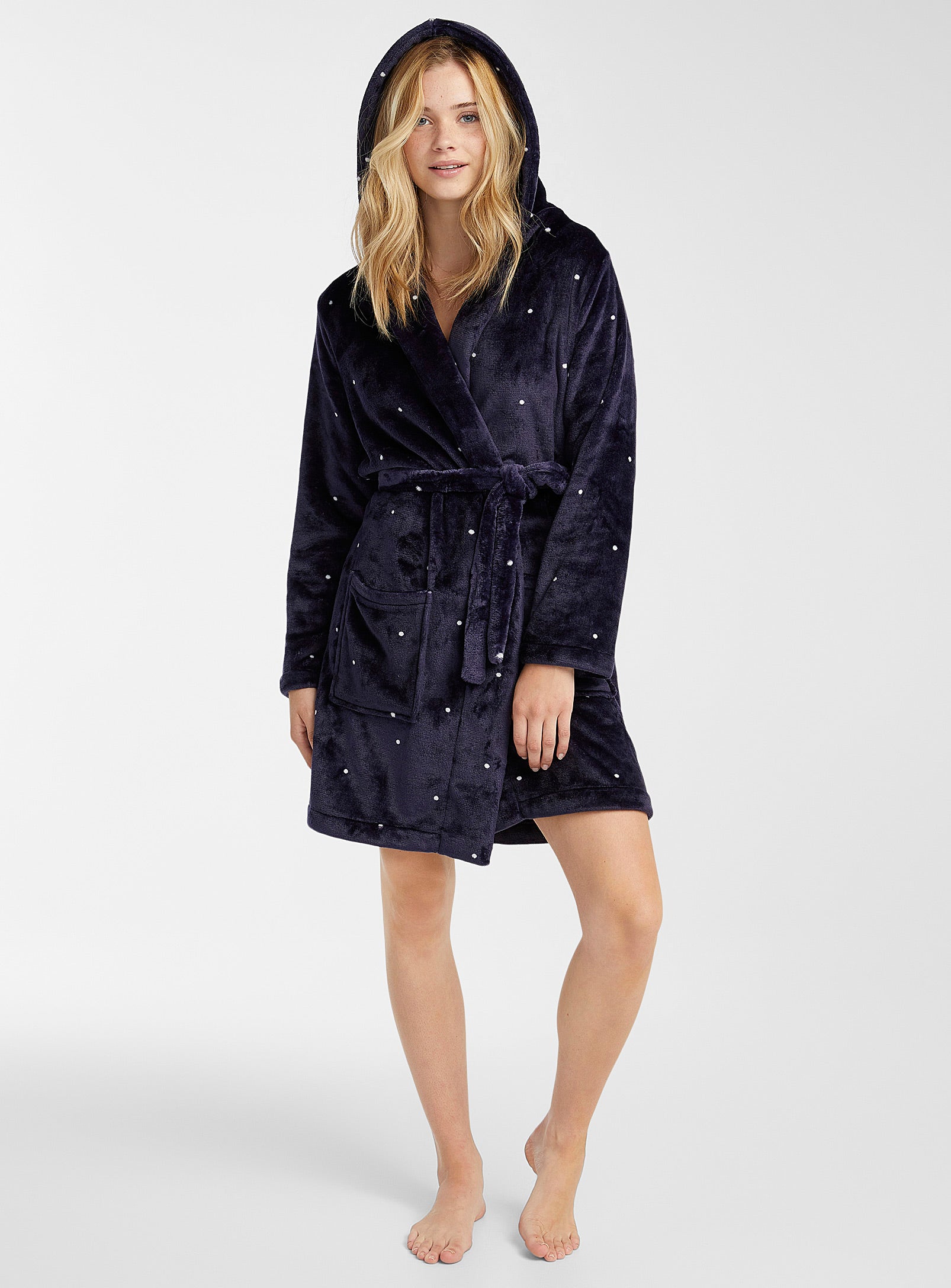 Woman in navy robe with white polka dots on it it.