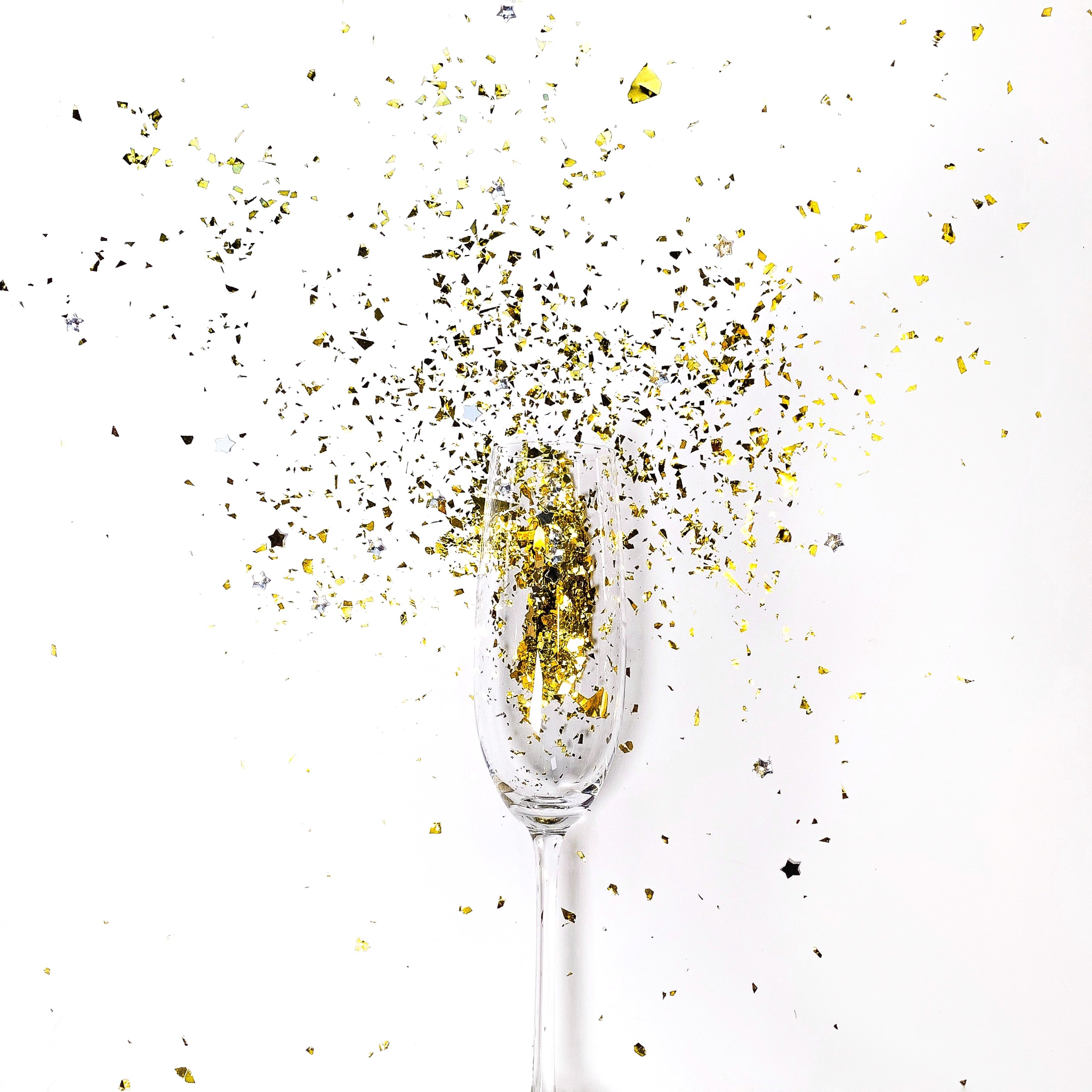 Champagne glass with gold glitter inside.