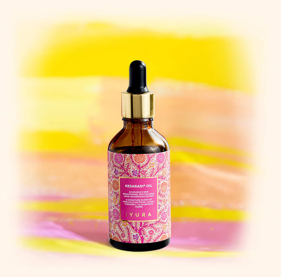 This is a product image of Kesaradi Oil bottle on a pink and yellowish background.