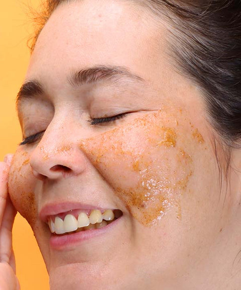 Adult woman smiling and applying Citrenis on her cheeks.