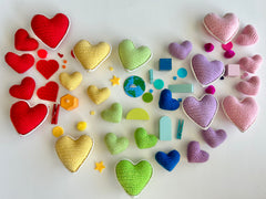 A rainbow of knit hearts assembled in a larger heart shape- FPK Knit Heart Collection