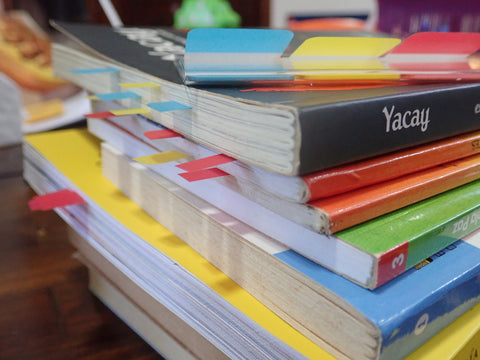 A stack of books with post-it note flags sticking out of the pages.