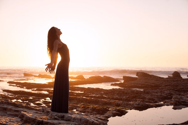 Woman meditating by the ocean Aromatics International