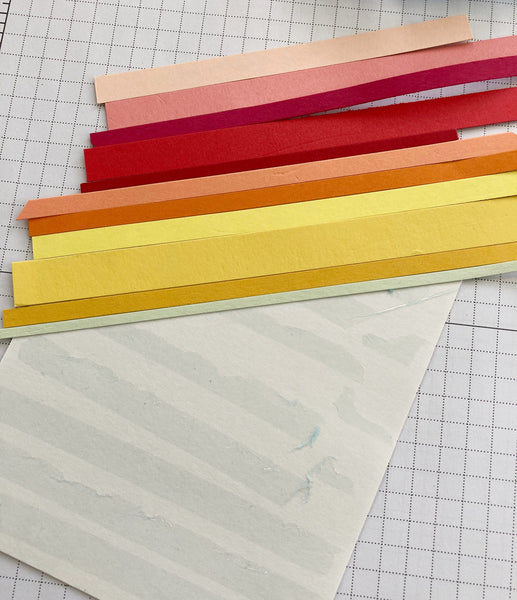 pink, red, orange and yellow paper strips on a white card background