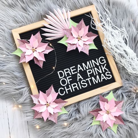 glitter paper poinsettias on a black letterboard sign