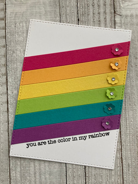 rainbow cardstock strips on a white background with flowers