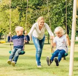 swing sets with mum pushing kids