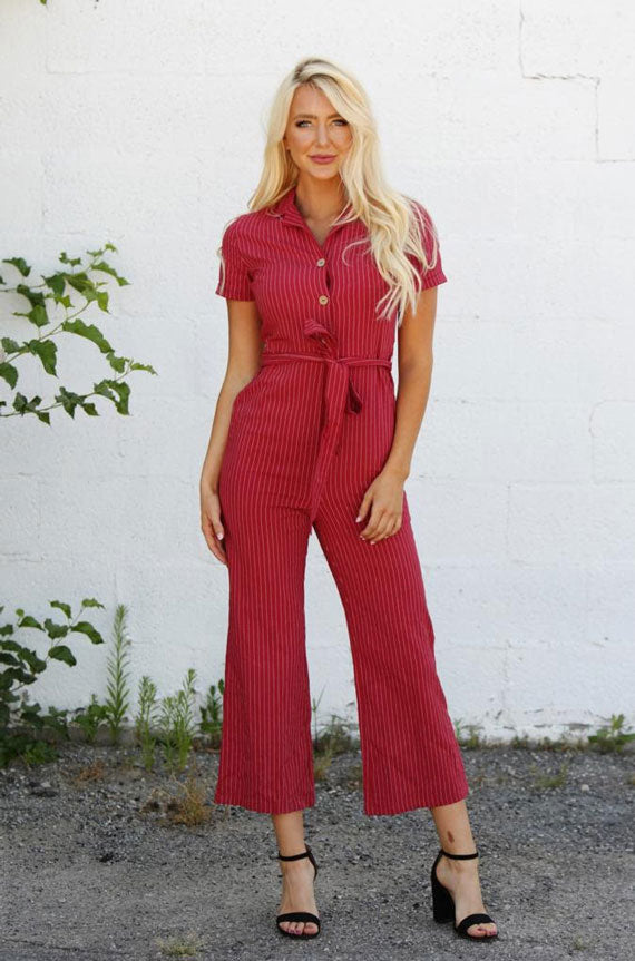 a woman modeling a red tie-waist jumpsuit