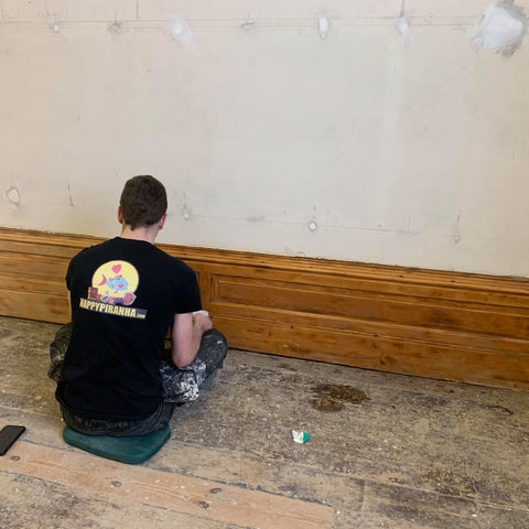 Josh oiling the skirting board after it being stripped of paint and sanded.