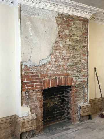 The principal function room's fireplace after having been uncovered once again.