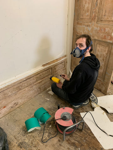 Sam stripping paint off the skirting in what will be the principal function room.