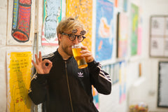 Ollie Gomm Gommie drinking beer at Poetry Art Exhibition