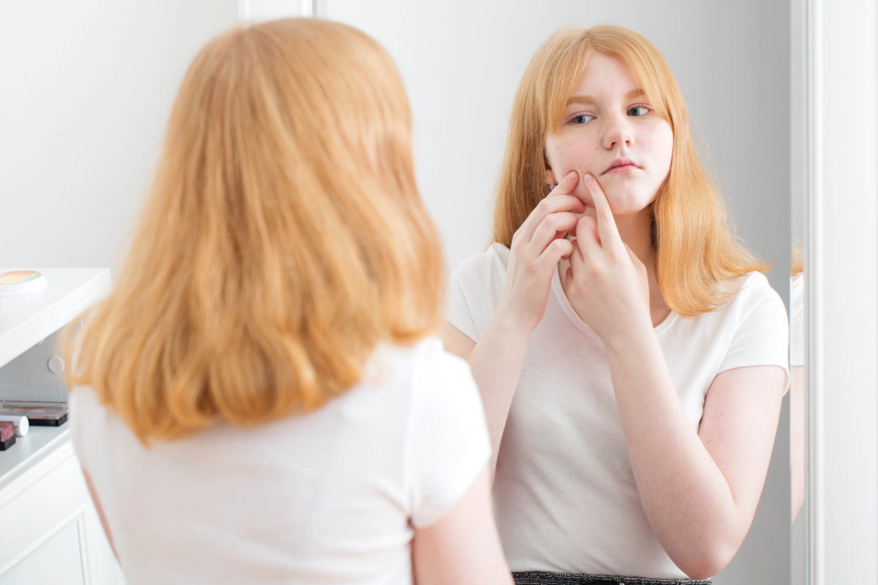 Young, teenage girl looking at her acne in the mirror. | 5 Game-Changing Things You Should Know About Acne | TEENOLOGY