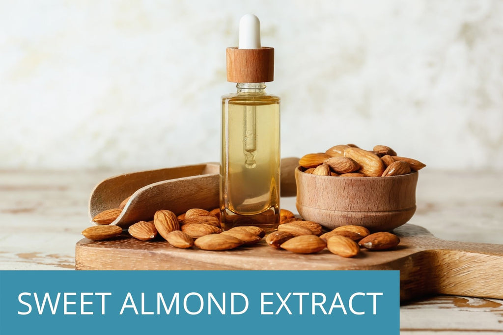 several fresh almonds next to a glass bottle of almond extract - a key ingredient in TEENOLOGY products to boost hair and skin health