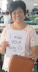 Loretta, one of FERRON's factory worker holding "I made your bag" sign