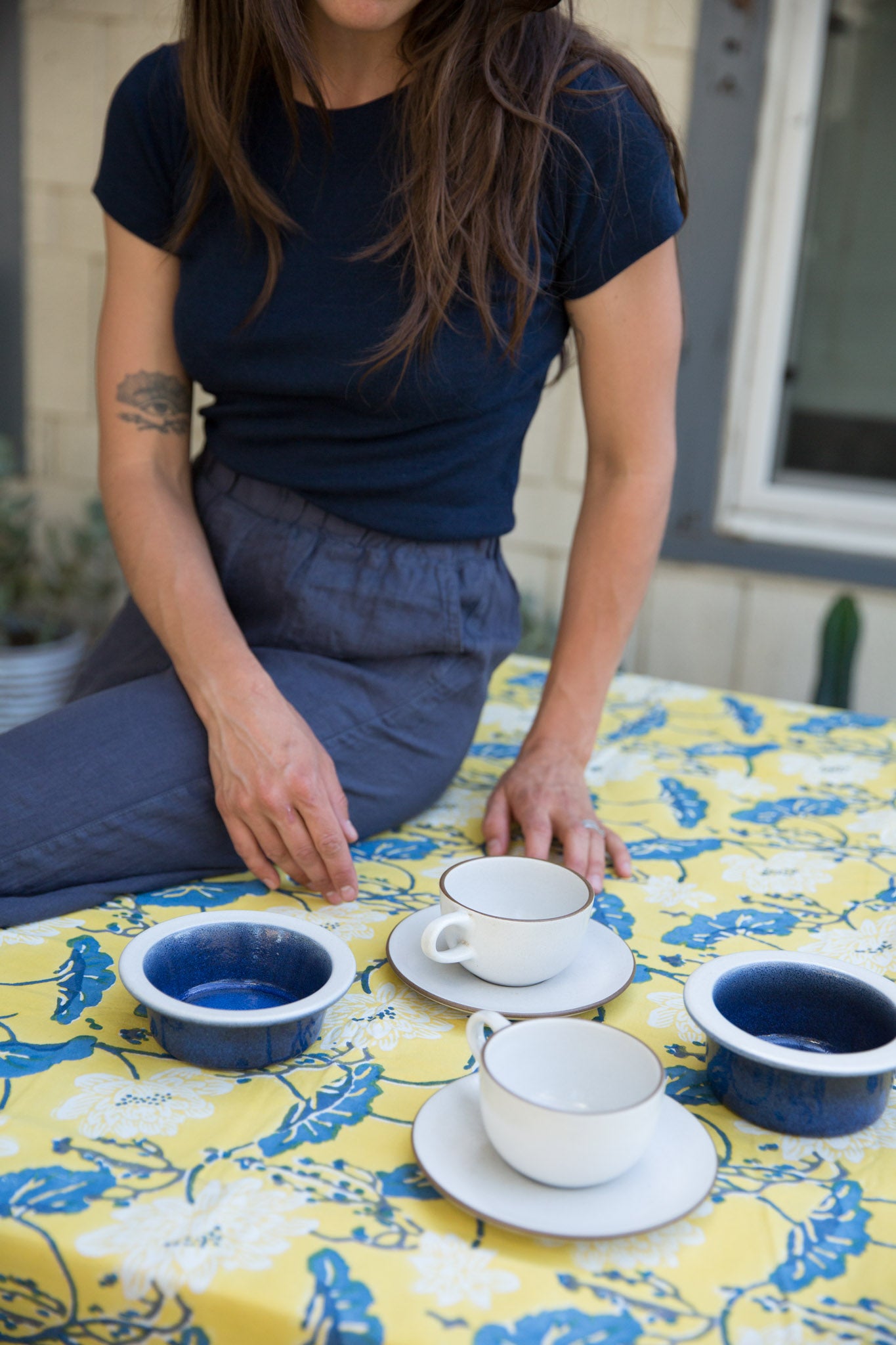yellow and blue tablecloth with blue and white tea cup set