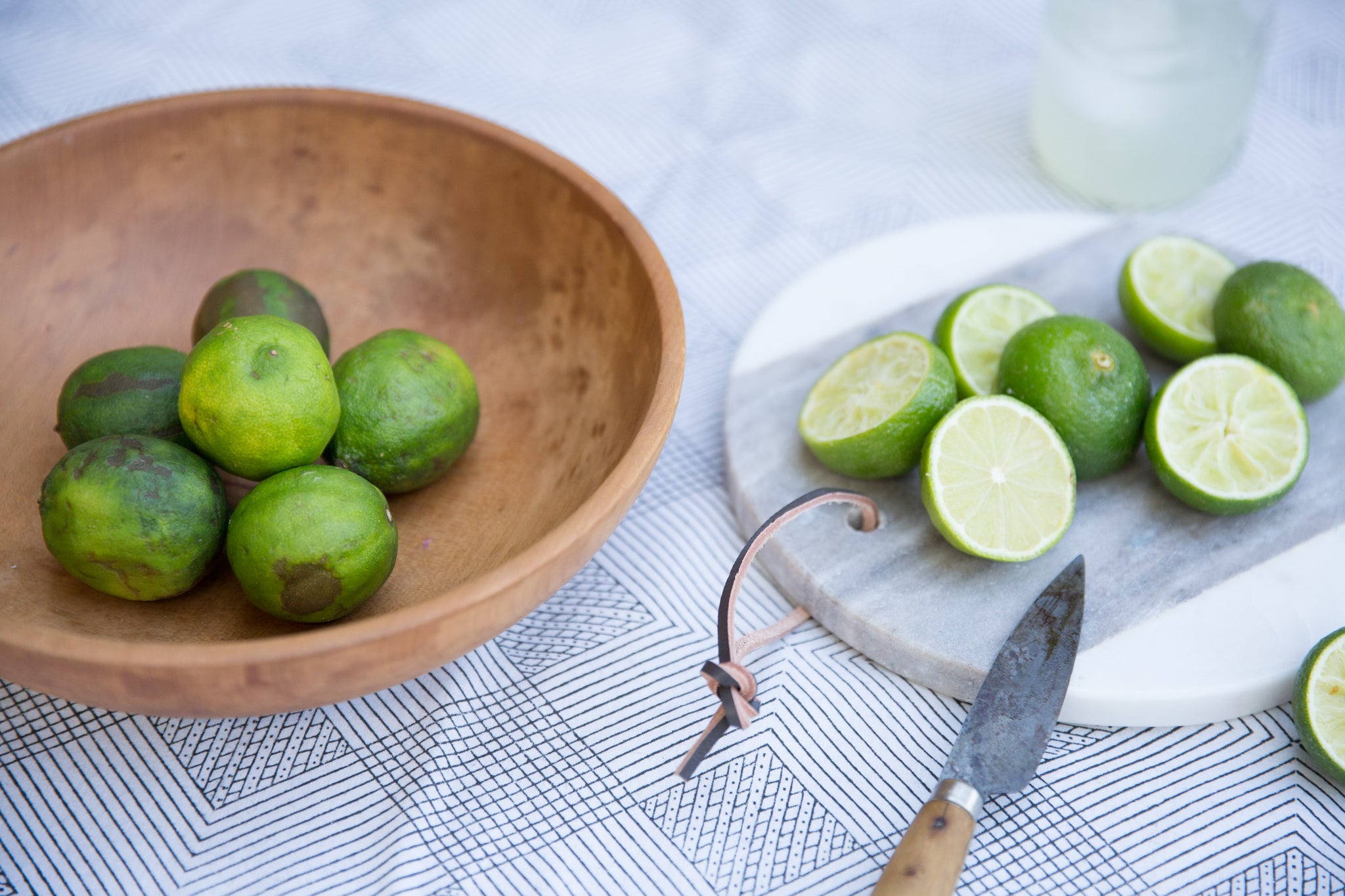 wooden bowl and cutting board holding limes