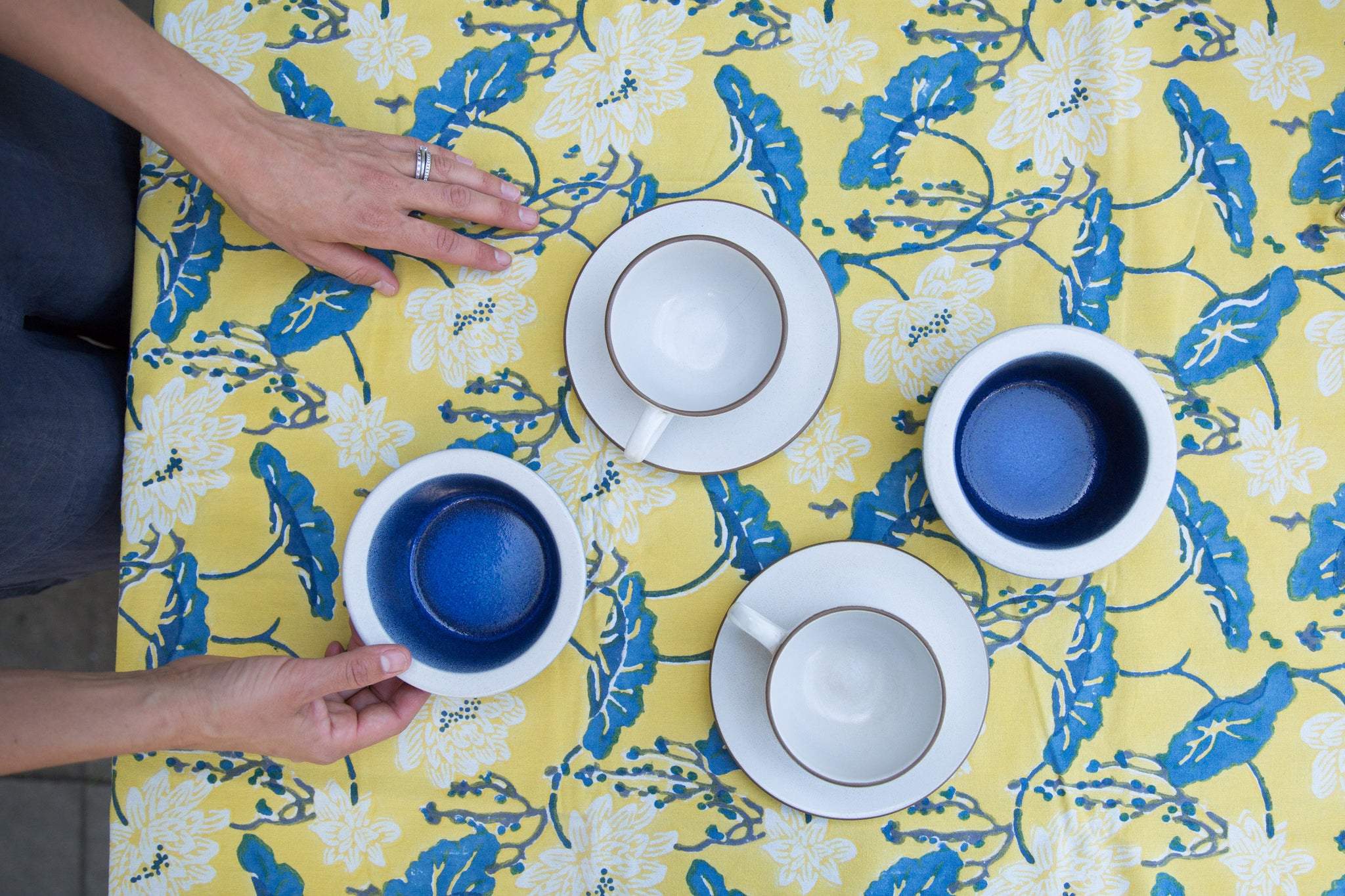 yellow and blue tablecloth with blue and white tea cup set