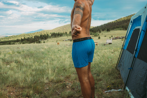 Blue men's boxers on male underwear model standing outside in nature