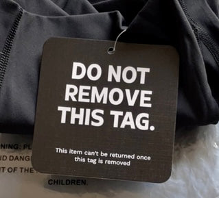 Black clothing tag stating “Do Not Remove This Tag.”