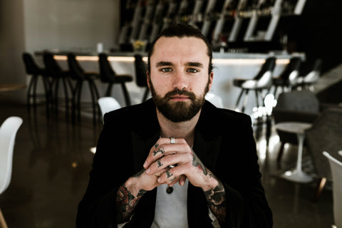 picture of pierced and tattooed man sitting down