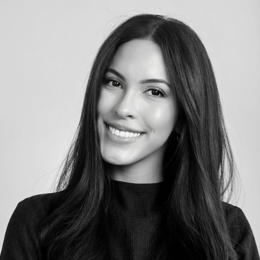 Black and white portrait of a smiling woman with long hair.