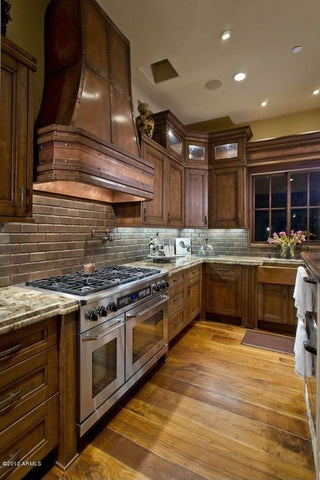 tall custom copper range hood in hight ceiling kitchen