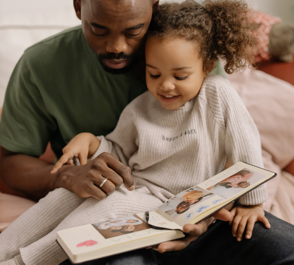 black father and daughter look at photos