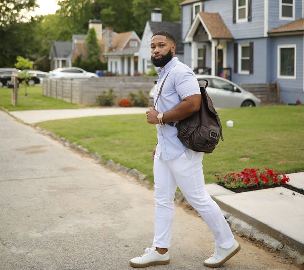 black man carrying leather backpack