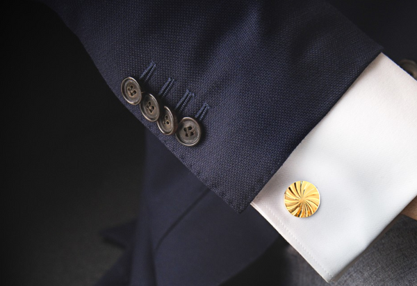 Gold cufflinks and navy blue suit
